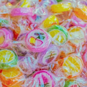 Vibrant close-up of colorful fruit-shaped candies, highlighting texture and sweetness.